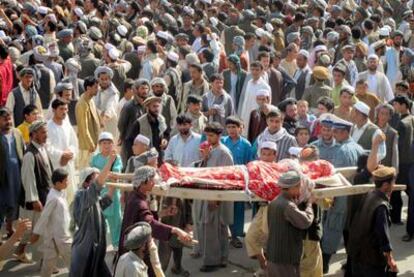 Afganos portan el cadáver de uno de los cuatro muertos durante una incursión anoche de la OTAN en Taloqan (norte). La policía ha disparado para dispersar la protesta, causando 10 muertos.