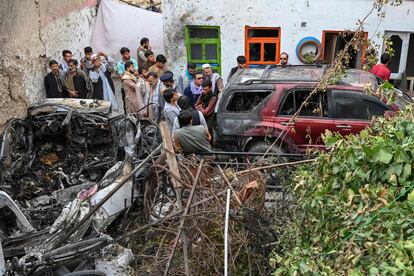 Vecinos y familiares de las víctimas junto al vehículo bombardeado por un dron estadounidense en Kabul el domingo.