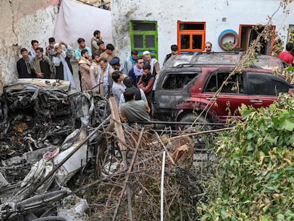 Vecinos y familiares de las víctimas junto al vehículo bombardeado por un dron estadounidense en Kabul el domingo.