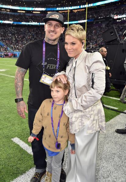 Pink, encargada de cantar el himno nacional estadounidense antes del incio del partido, en el césped del U.S. Bank Stadium con su marido y su hija.