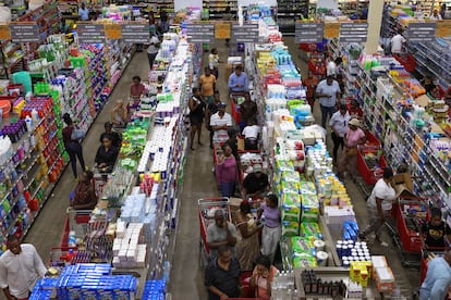 Personas hacen fila en un supermercado al comprar víveres en preparación para el paso de 'Beryl', este lunes.