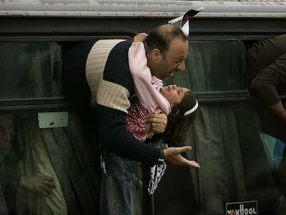 Un preso palestino recién liberado ayer de una cárcel israelí abraza a su hija en un puesto de control cerca de Cisjordania.