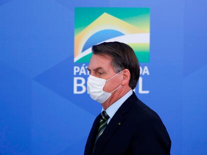 El presidente de Brasil, Jair Bolsonaro, llega con barbijo a la sala de prensa del Palacio Planalto.