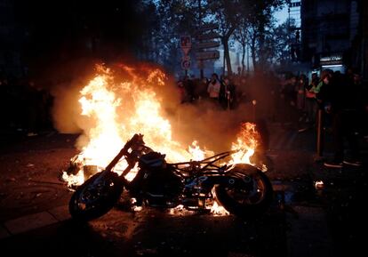 La manifestación que este sábado se alzó en París contra una nueva ley concluyó con al menos 46 personas detenidas y en 23 agentes heridos, según cifras respectivas de la Prefectura de Policía y del Ministerio del Interior. En la imagen, manifestantes observan una motocicleta incendiada en París.