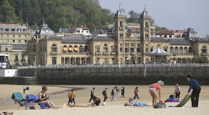 Varios turistas toman el sol en la playa de La Concha en San Sebastián. 