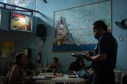 Una mujer ordena un platillo, en el restaurante Buzos de Acapulco.