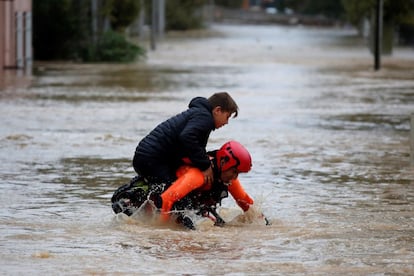 Un bombero saca a un niño a sus espaldas de una calle inundada en Trèbes (Francia). El nivel del agua aumentó en Trèbes ocho metros en solo cinco horas. No se registraban cifras similares desde 1891. En otros municipios, los niveles son superiores a dos metros de agua.