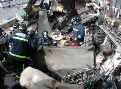 Los bomberos trabajan entre los restos de uno de los vagones donde estallaron las bombas de la estación de El Pozo.