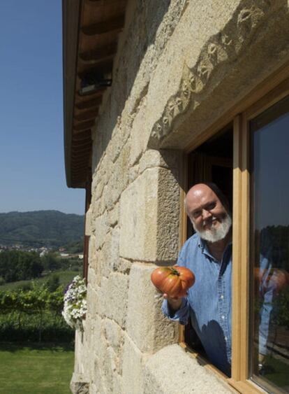 José Luis Cuerda posa con un de los espléndidos tomates de su huerta, en su casa de Allariz (Ourense)