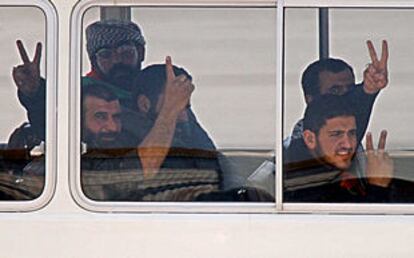 Algunos de los 13 palestinos deportados hacen la señal de la victoria desde un autobús en el aeropuerto de Chipre.
