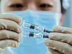 In this photo released by Xinhua News Agency, a medical worker inspects COVID-19 inactivated vaccines at a packaging plant of the Beijing Biological Products Institute Co., Ltd. in Beijing on Dec. 25, 2020. China on Wednesday, Feb. 3 announced a plan to provide 10 million coronavirus vaccine doses to developing nations through the global COVAX initiative. (Zhang Yuwei/Xinhua via AP)