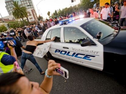 Los manifestantes golpean uno de los coches de la policía que intentó disolver la protesta el pasado martes en Anaheim, California.