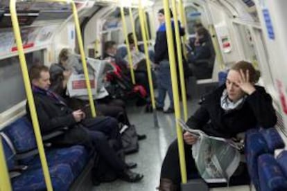 Una mujer lee un periódico mientras viaja en un vagón del metro de Londres, en Reino Unido. EFE/Archivo