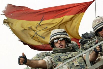 Un legionario español saluda desde un blindado antes de cruzar la frontera con Kuwait durante la retirada de las tropas de Irak en mayo de 2004.