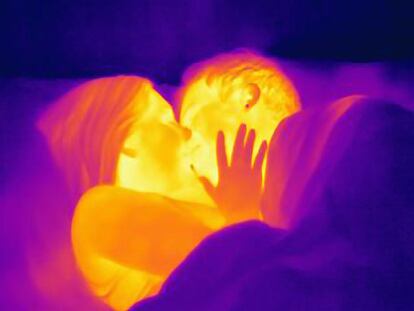 Thermal image of young couple kissing in bed