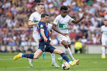 Lewandowski frente a Gumbau y  Nwankwo, en el partido entre el Barcelona y el Elche.