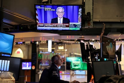 Un operador de Wall Street sigue por televisión la comparecencia de Jerome Powell, responsable de la Fed, el 15 de diciembre.