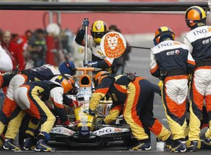 Mecánicos de Renault asisten a Fernando Alonso ayer en el circuito de Montmeló.