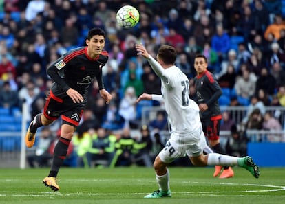 El centrocampista del Celta de Vigo Pablo Hernández (i) compite en el centro del campo por un balón con el delantero del Real Madrid Borja Mayoral.