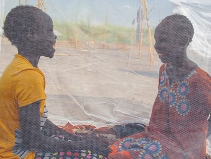 Unas adolescentes charlan protegidas por una mosquitera en Sudán del Sur.
