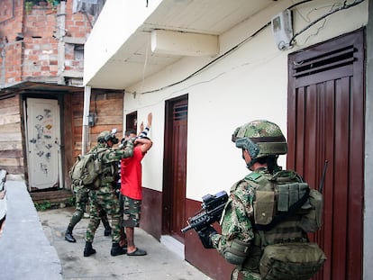 Soldados registran a una persona durante un patrullaje a pie en los callejones del barrio Comuna 13 en Medellín, Colombia.