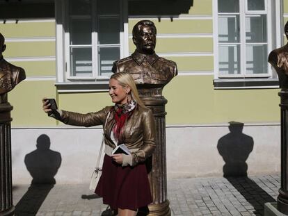 Una mujer se hace una foto delante de las esculturas de los líderes soviéticos Nikita Jruschev, Stalin y Lenin, en Moscú.