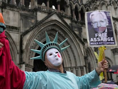 Un manifestante disfrazado como la Estatua de la Libertad, protesta ante el Tribunal Superior de Justicia por la acusación contra Assange