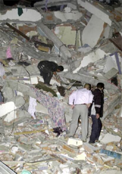 Los equipos de rescate buscan víctimas en los restos de un edificio derruido.