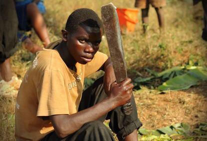 Un joven batwa sostiene un machete que usa para sacrificar a la vaca que una ONG ha regalado a su pueblo. Durante el genocidio de Ruanda en 1994, los Tutsi fueron asesinados a machetazos por los Hutu con este instrumento.