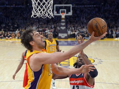 Pau Gasol lanza ante el brasileño Nene, de los Wizards, en su regreso. Al fondo, Howard. 