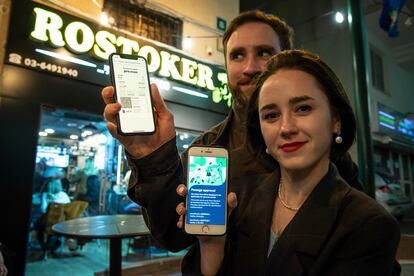 Olga Rerbo, de 29 anos, e Nathan Read, de 32, mostram o passe verde em seus celulares antes de entrarem em um bar em Ramat Gan, na região metropolitana de Tel Aviv. 