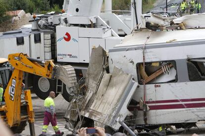 Trabajos de desmontaje y retirada de uno de los vagones siniestrados en el accidente de tren ocurrido anoche en Santiago de Compostela en el que han muerto al menos 78 personas.