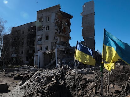 Ukrainian flags wave in front of damaged residential buildings in Orikhiv, near the frontline in the Zaporizhzhia region