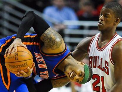 Carmelo Anthony mantiene la bola ante Jimmy Butler.