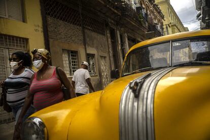 Dos mujeres protegidas con mascarillas caminan por una calle de La Habana (Cuba).