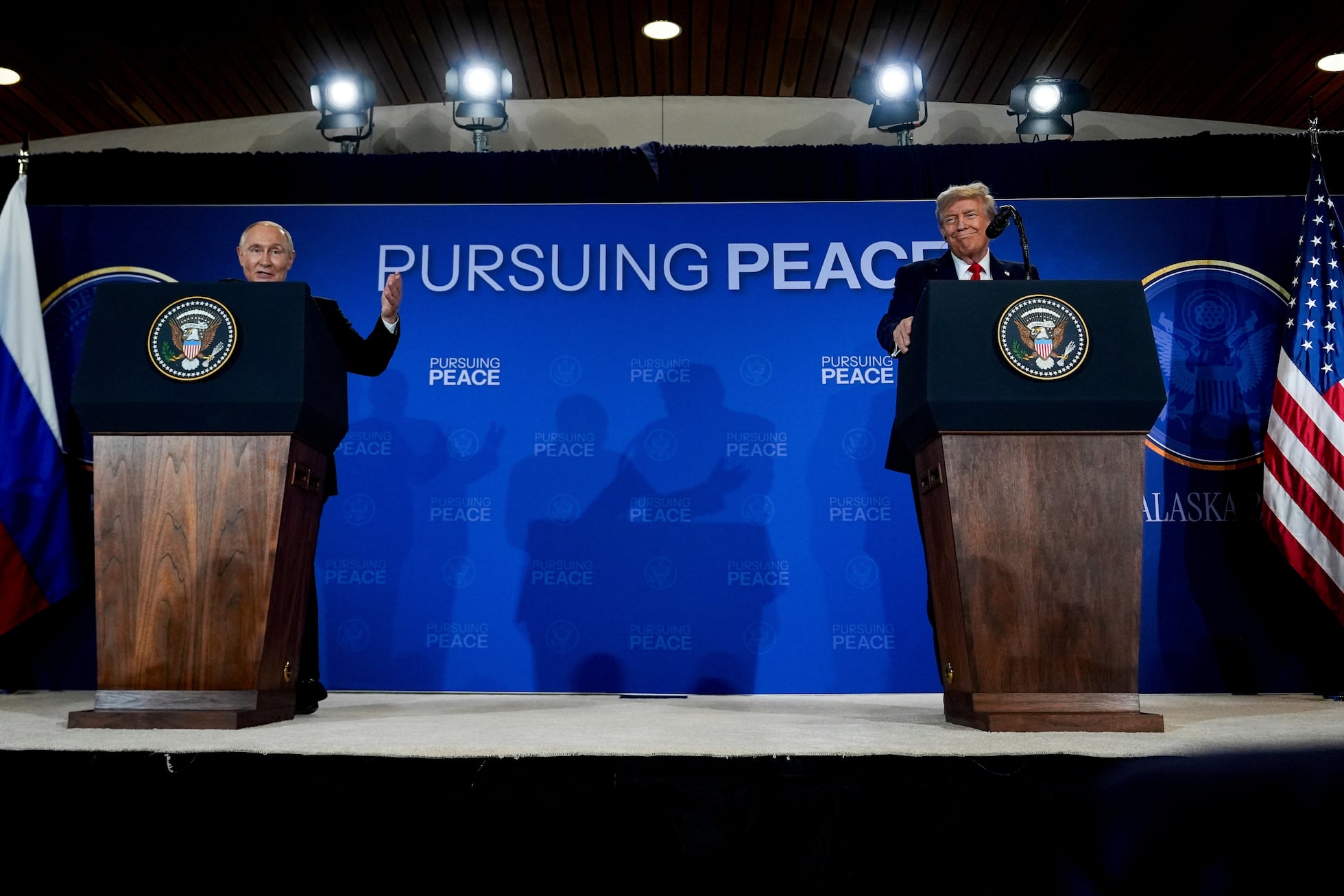 Trump Putin Alaska meeting handshake symbolizing betrayal of democracy and U.S. weakness
