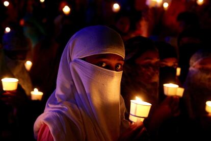 Miembros de la Comisión Estatal de Karnataka para la Protección de los derechos de las Mujeres y la Infancia, estudiantes de diferentes universidades, activistas y otros miembros de organizaciones no gubernamentales sostienen velas y pancartas mientras gritan consignas durante una protesta por la violación y asesinato de una niña nómada de ocho años, en Bangalore (India).