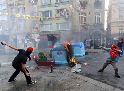 Dos manifestantes lanzan piedras a los agentes turcos en las calles de Estambul.