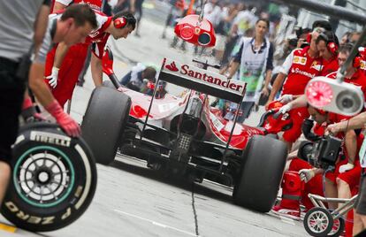 Alonso espera en el taller durante los entrenamientos de la mañana. 