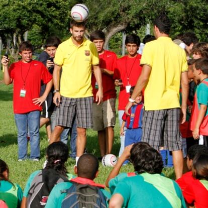 Gerard Piqué y Sergio Busquets (de espaldas) juegan rodeados por un grupo de niños ayer en Miami.