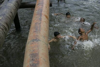 Archive picture in which children play in a river in Sucumbios, Ecuador, next to a Chevron pipeline.