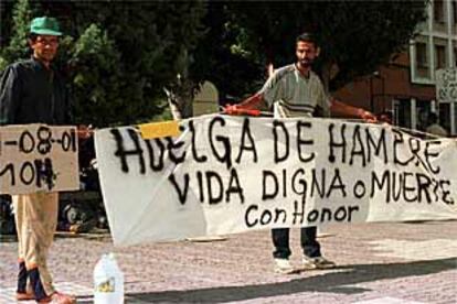 Los inmigrantes de Las Pedroñeras extienden un pancarta de protesta en Cuenca.