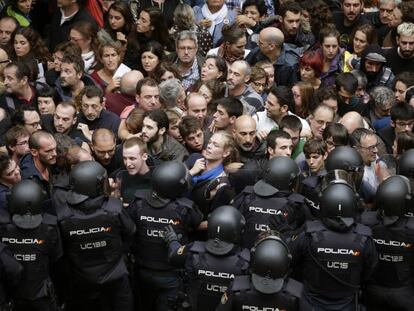 Agentes antidisturbios de la Policía Nacional forman un cordón de seguridad en los alrededores del colegio Ramón Llull de Barcelona. 