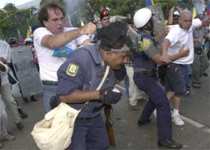 Un manifestante golpea a un policía hoy en Caracas.