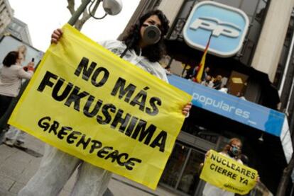Activistas de Greenpeace escalan las sedes del PP y PSOE para reclamar el abandono de la energía nuclear en España.