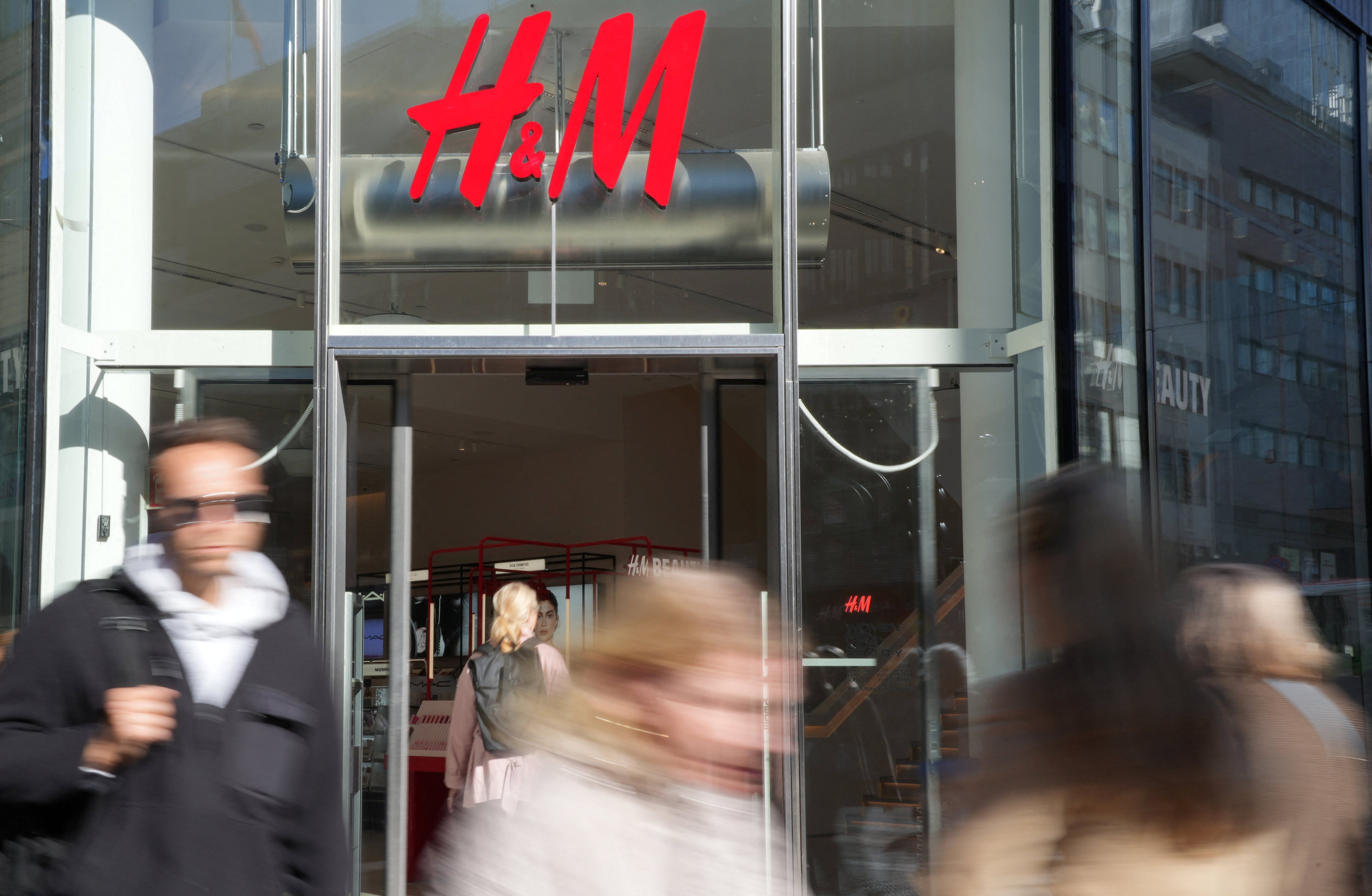 Pedestrians walk past a branch of H&M in Stockholm, Sweden, September 23, 2025. REUTERS/Tom Little