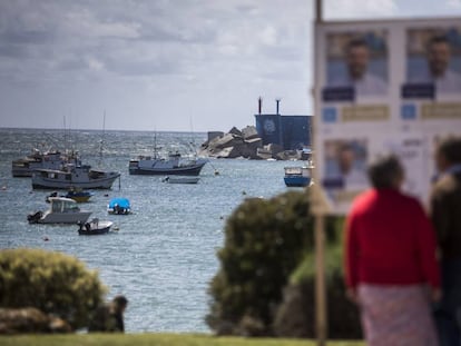 Varias personas observan carteles electorales en el puerto de A Guarda el pasado viernes.