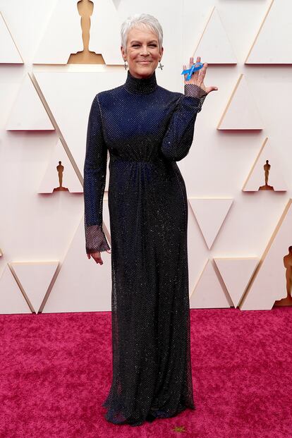 Jamie Lee Curtis, con vestido tornasolado de Stella McCartney, a su llegada a la alfombra roja de los Oscar. La actriz portaba en la mano un lazo azul de apoyo a los refugiados.