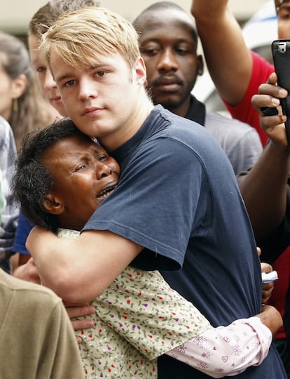 Unas personas se abrazan en el exteriro de la residencia de Nelson Mandela en Johanesburgo (Sudáfrica), 6 de diciembre de 2013.
