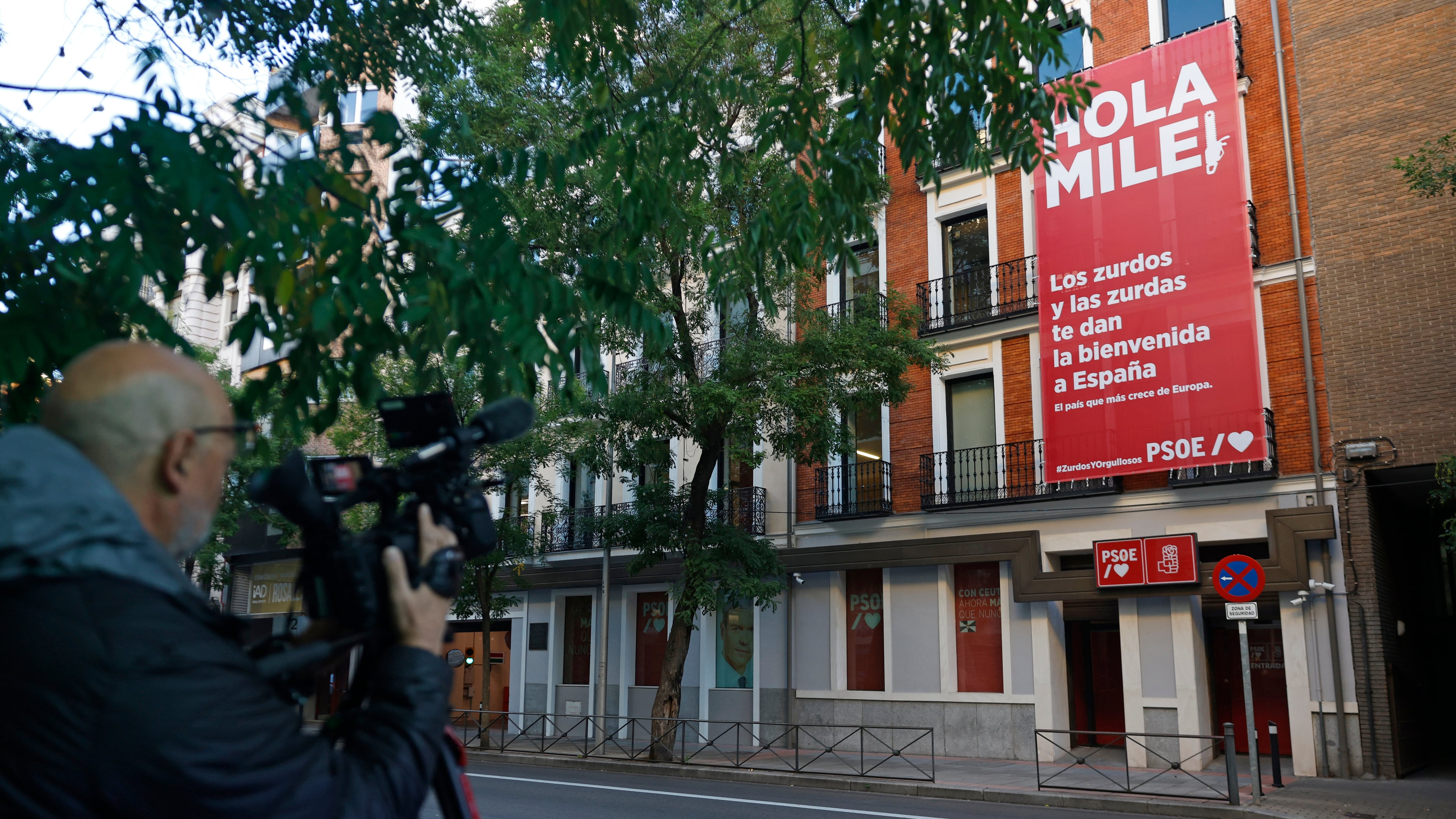 Sánchez da la bienvenida a Milei con una lona en Ferraz y un vídeo: “Orgullosos de ser zurdos”